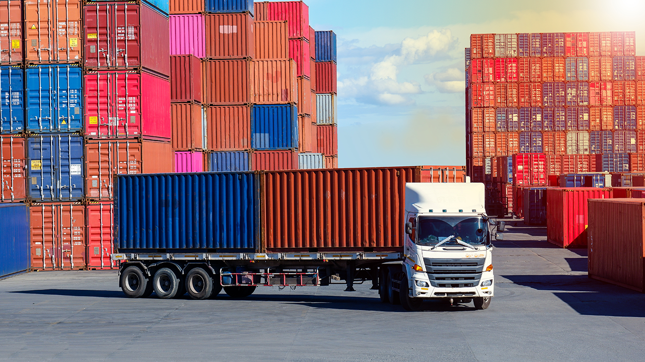 Container-LKW und gestapelte Container im Hintergrund